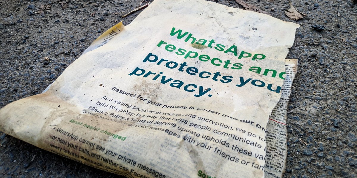 Zeitungsausschnitt - auf dem schmutzigen Boden liegend, Überschrift WhatsApp schützt Ihre Privatsphäre