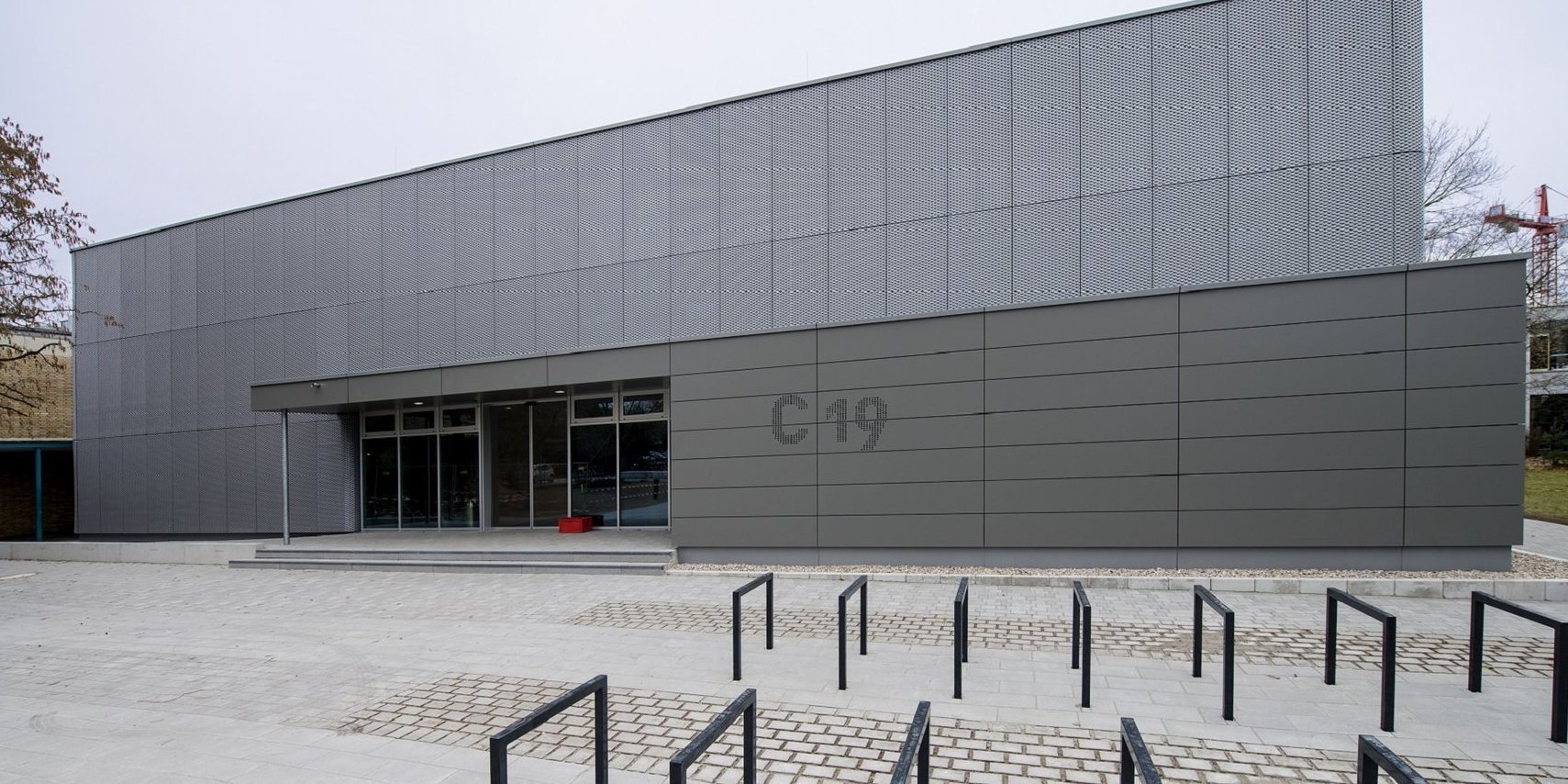 Blick auf die Metallfassade des Hörsaalgebäudes C 19 mit verglastem Eingangsbereich