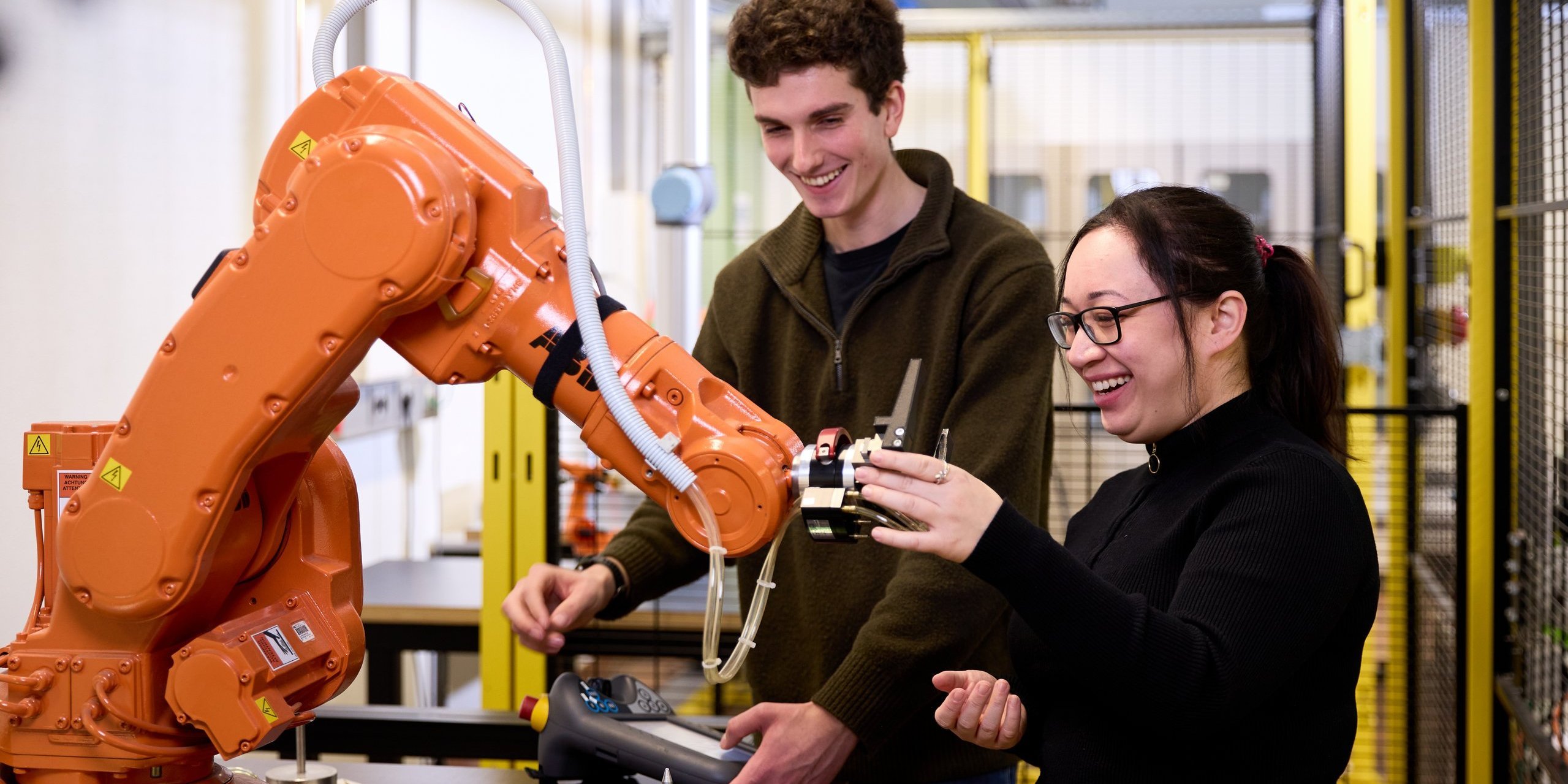 zwei Personen an Roboterarm