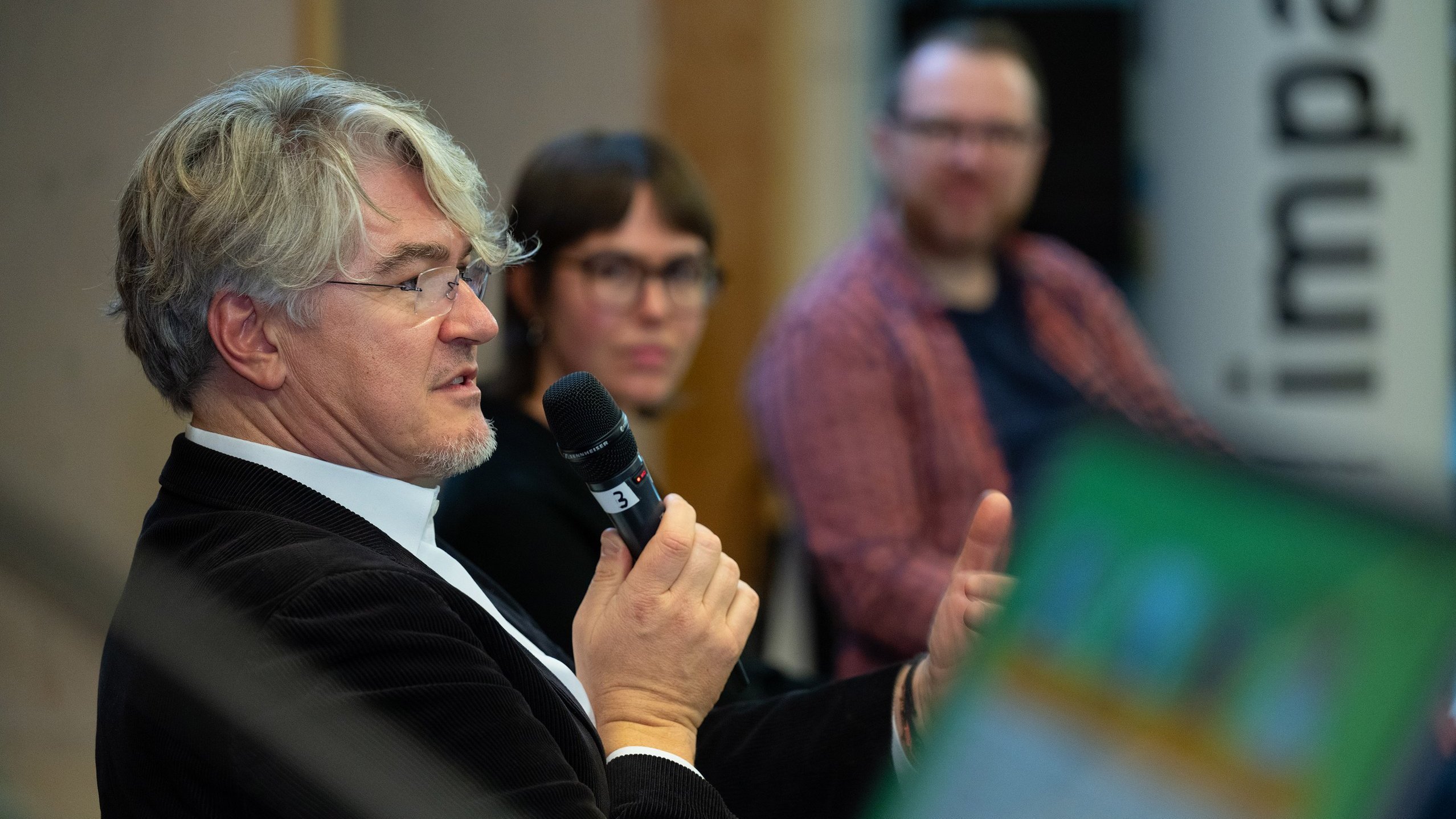 Lars Rademacher spricht, Leonie Heims und Rafael Bujotzek hören zu