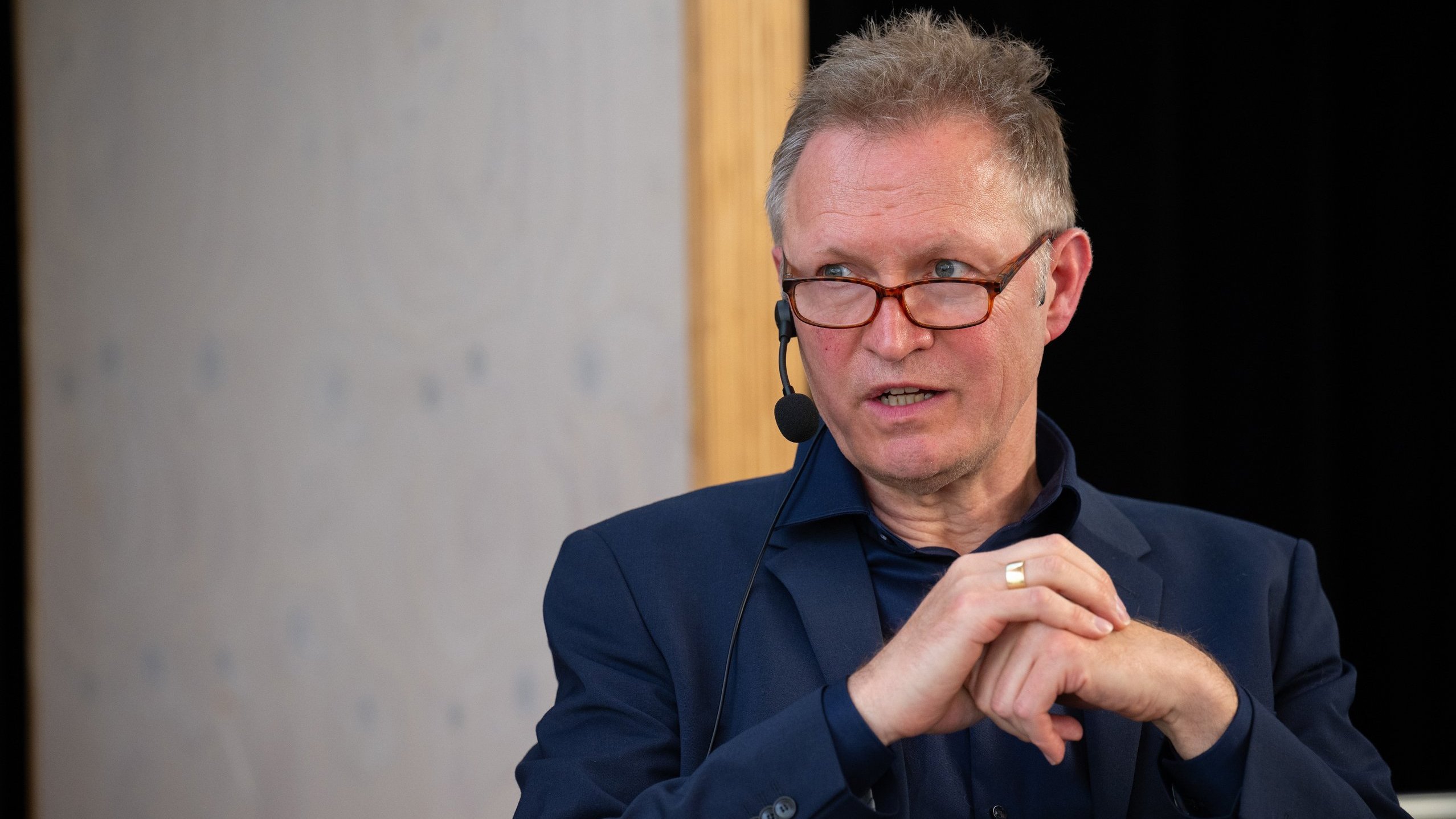 Moderator Thomas Döring stellt eine Frage und blickt die Adressatin an