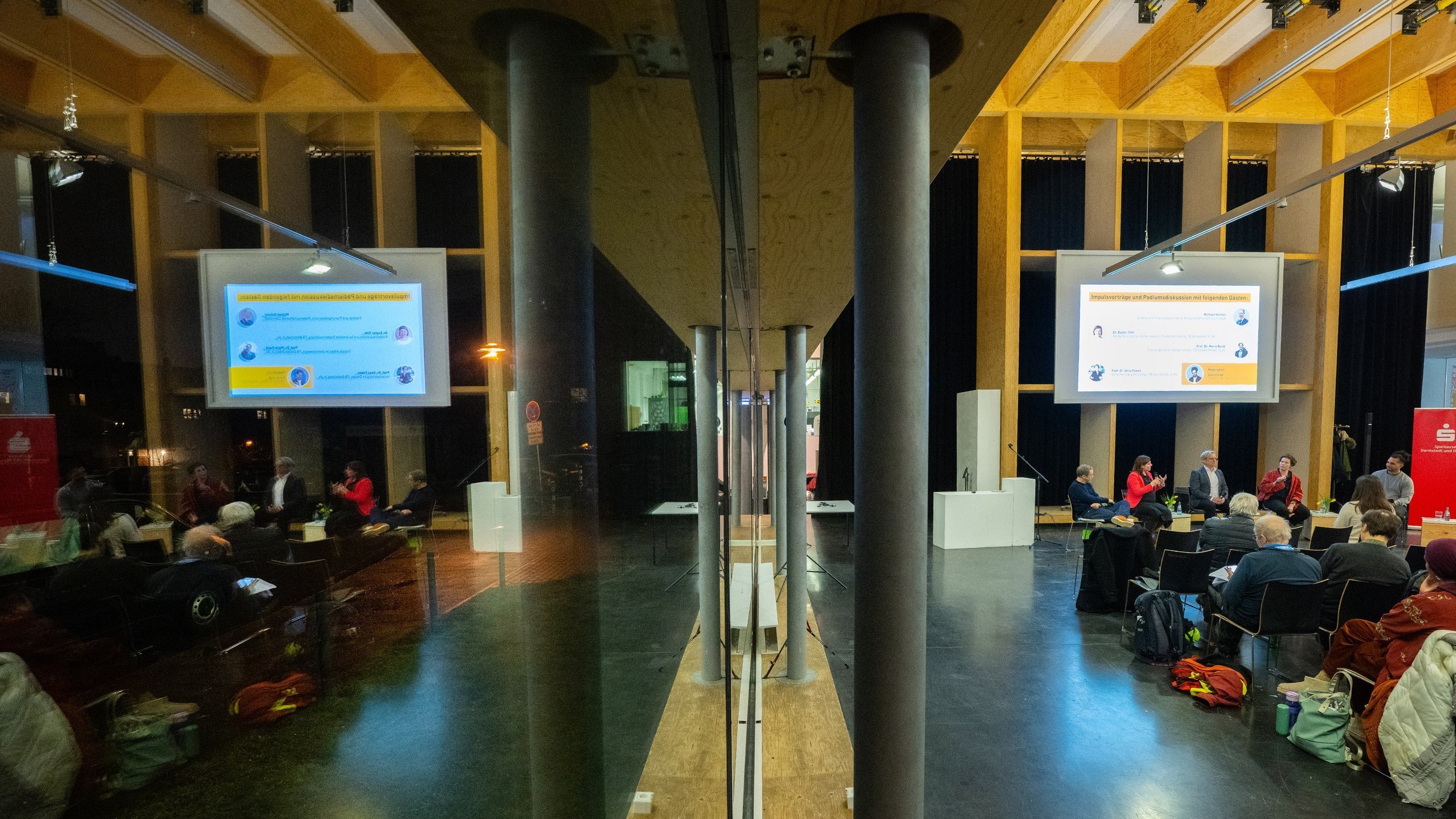 Das Innere des Saals spiegelt sich in der Glasfassade