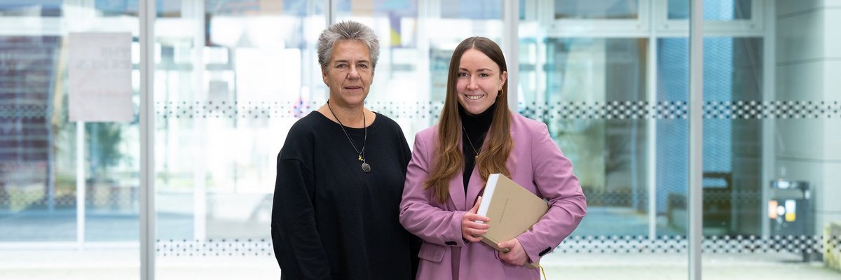 Auf dem Foto zu sehen ist Doktorandin Renée März (rechts) mit ihrer Promotionsarbeit unterm Arm und links Betreuerin Prof. Dr. Yvonne Haffner vom Fachbereich Soziale Arbeit. 