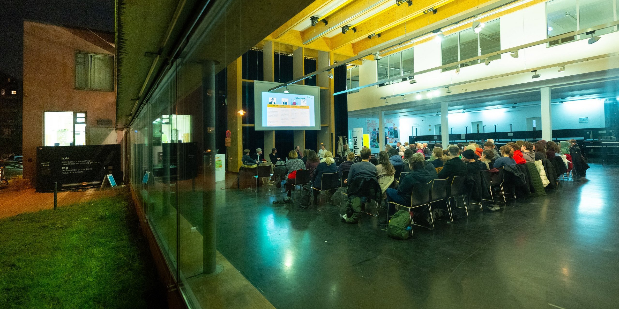 Blick von außen durch die Glasfassade in den Veranstaltungsraum