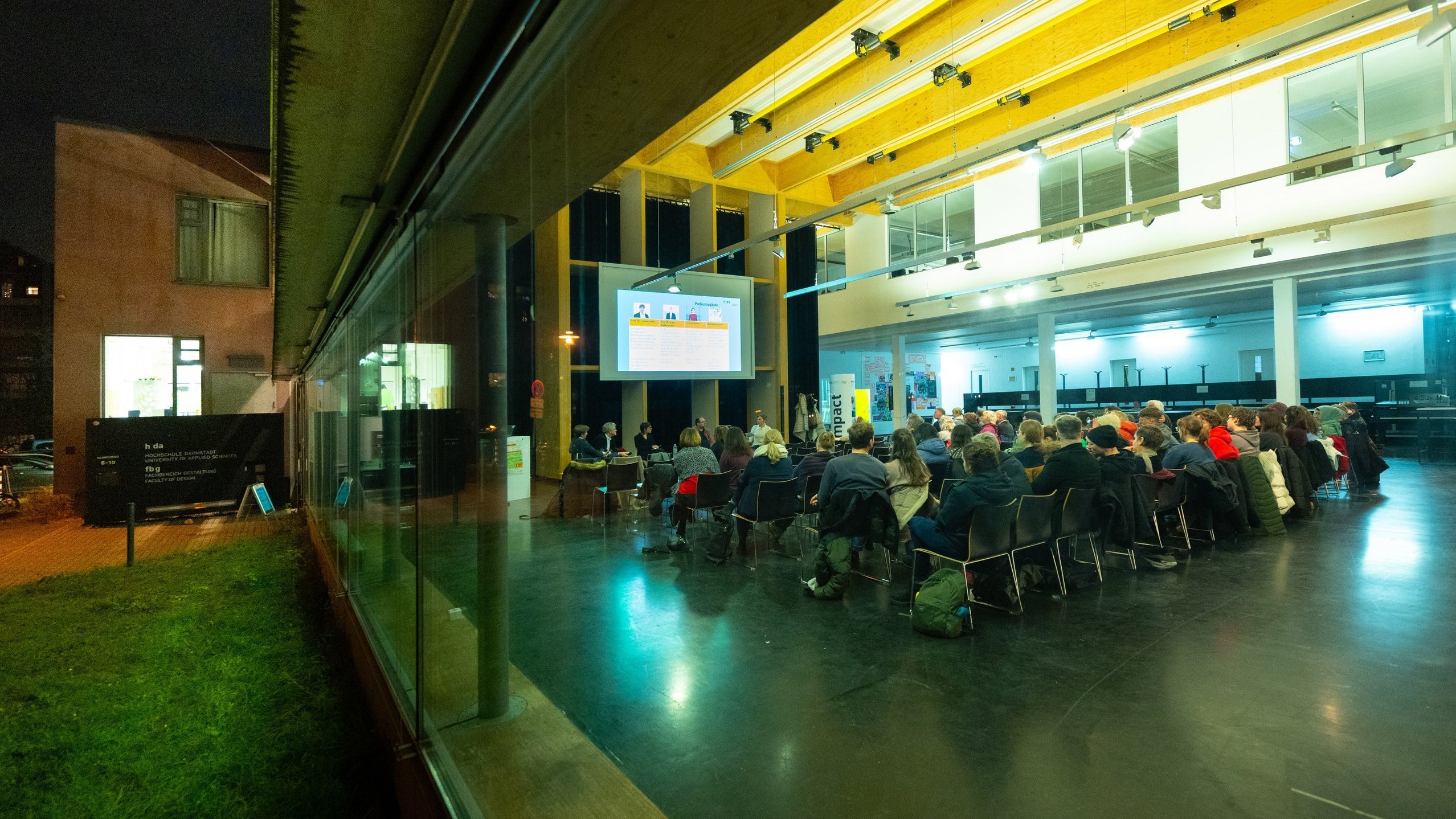 Blick von außen durch die Glasfassade ins Foyer des Fachbereichs Gestaltung