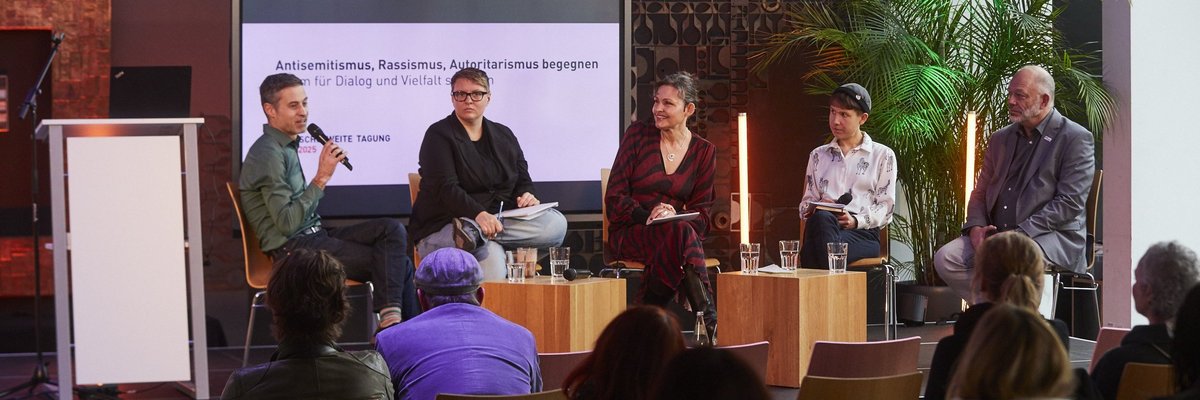Gruppe von Diskutierenden bei der Konferenz auf der Bühne