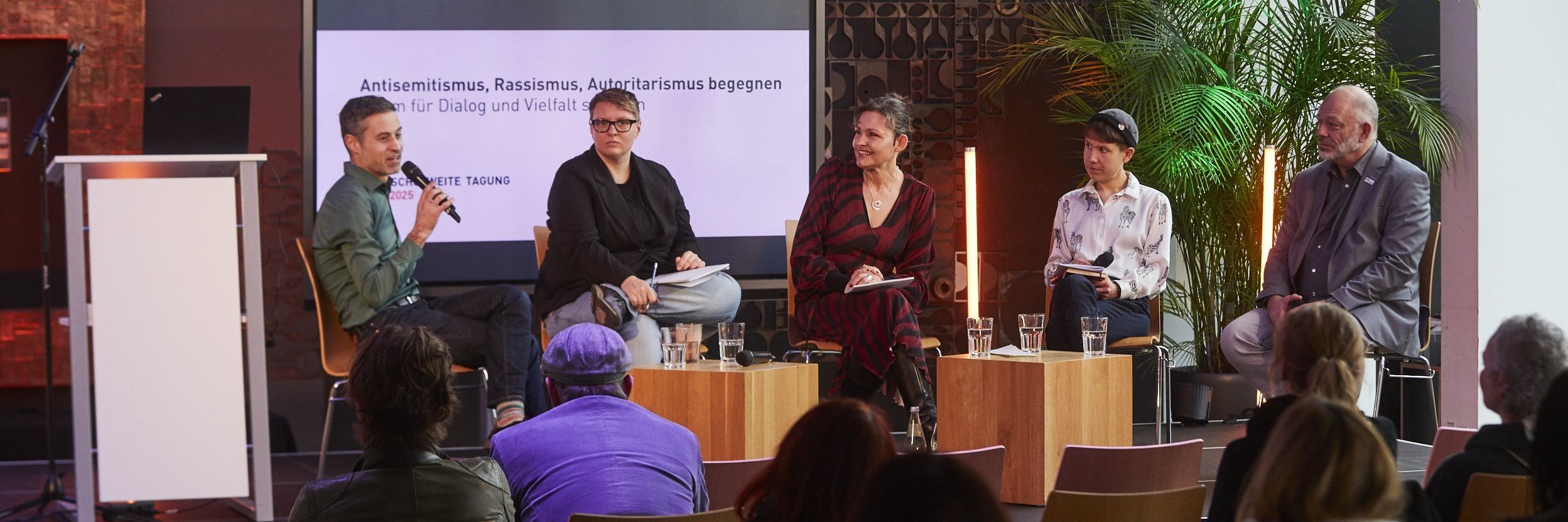 Gruppe von Diskutierenden bei der Konferenz auf der Bühne
