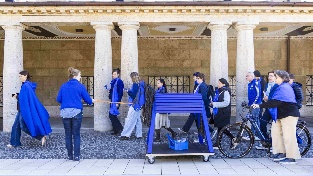 Blau gewandete Mitarbeitende des Museums Wiesbaden erregten mit einem Voltigierpferd mitten in der Stadt Aufmerksamkeit für die Schau "Die blauen Reiterinnen". Das Konzept für diese und weitere Aktionen entwickelten Studierende der Onlinekommunikation. Foto: Museum Wiesbaden/Samira Schulz