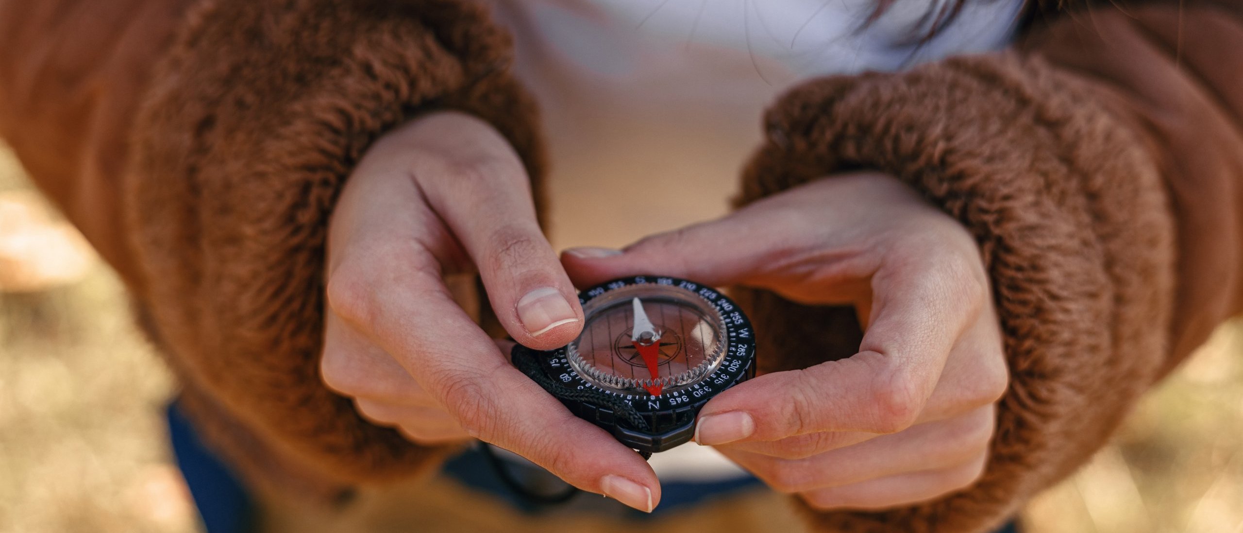 Zwei Hände halten einen Kompass