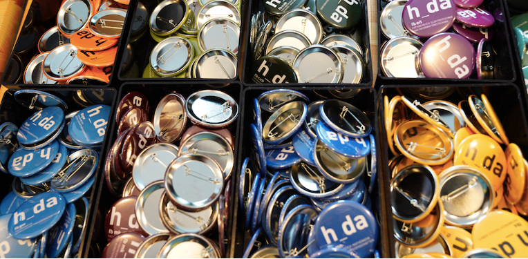 Symbolfoto von bunten Ansteck-Buttons mit h_da-Logo