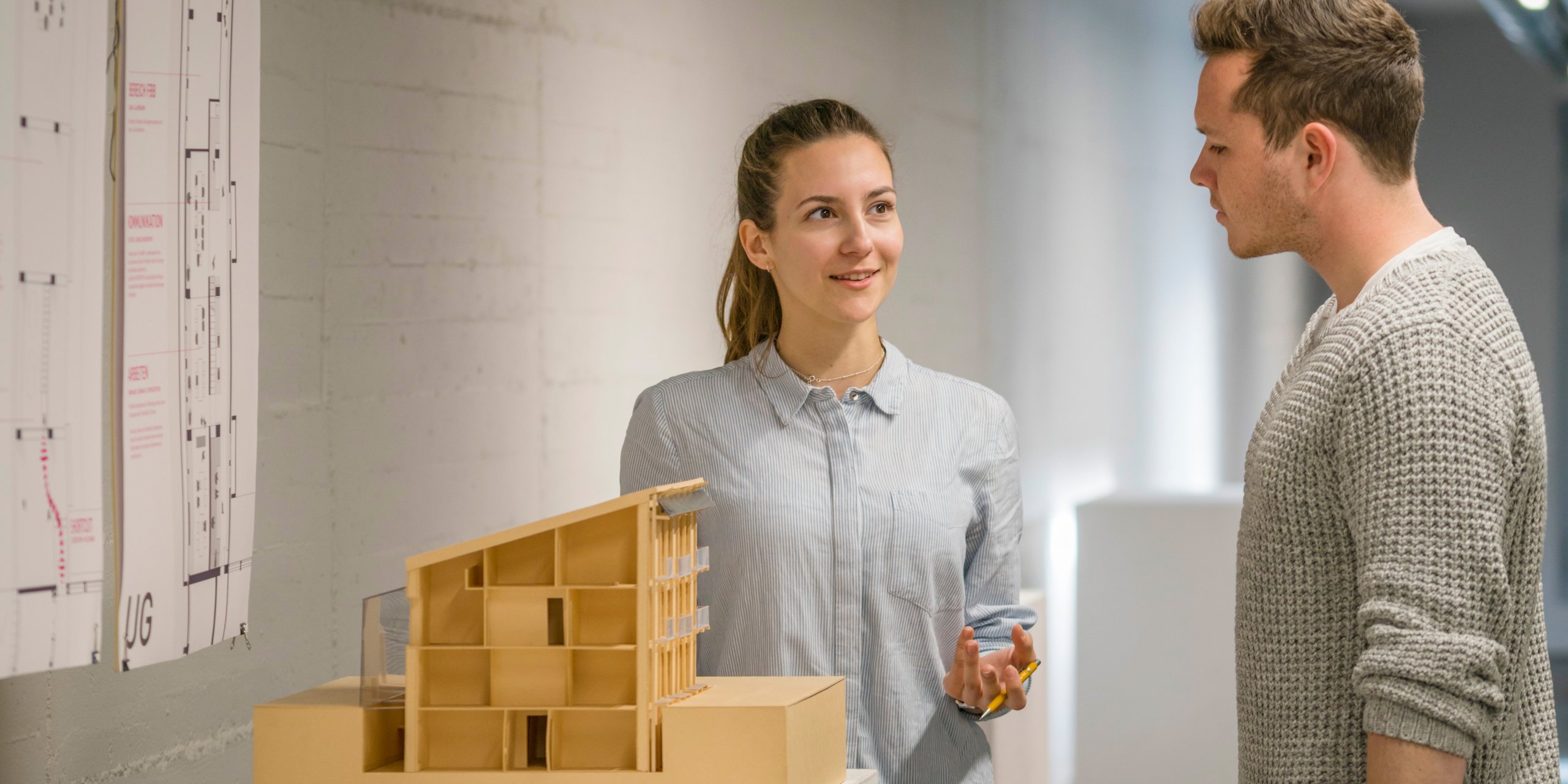 Eine Studentin und ein Student neben einen Architektur-Modell