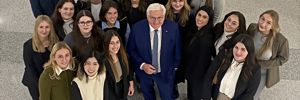 Das Foto zeigt den Bundespräsidenten, umringt von Studentinnen.