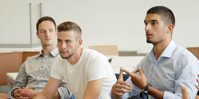 Drei Studierende, die in einem Seminar sitzen und zuhören.