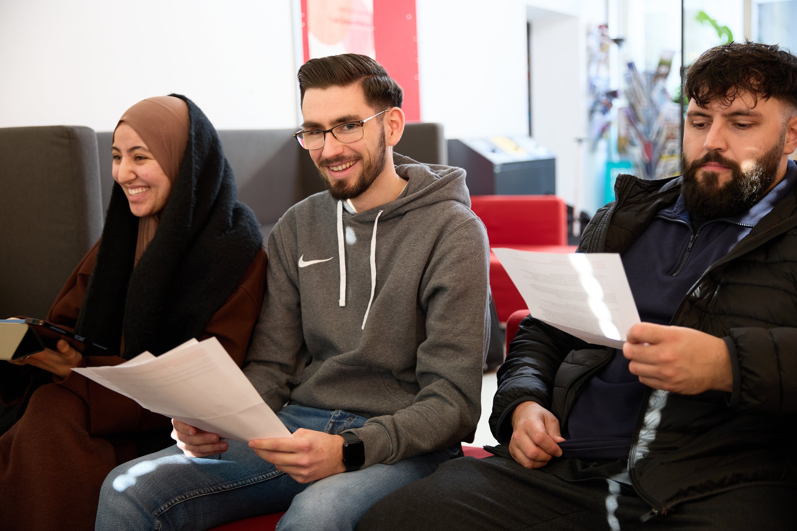 Drei Studierende lernen gemeinsam im Cafe